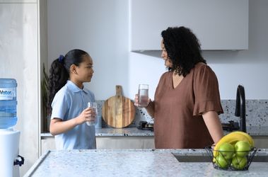 Mother and daughter in the kitchen drinking Just Water 