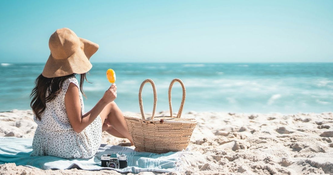 Woman sitting on the beach on a hot summers day